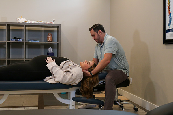 Doctor Kaleb Valdez performing a chiropractic adjustment on a pregnant woman