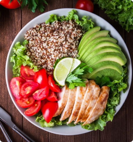 Bowl of healthy foods including tomatoes, chicken, and avocado promoting custom nutrition program