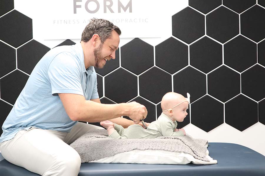 chiropractic doctor adjusting a baby girl